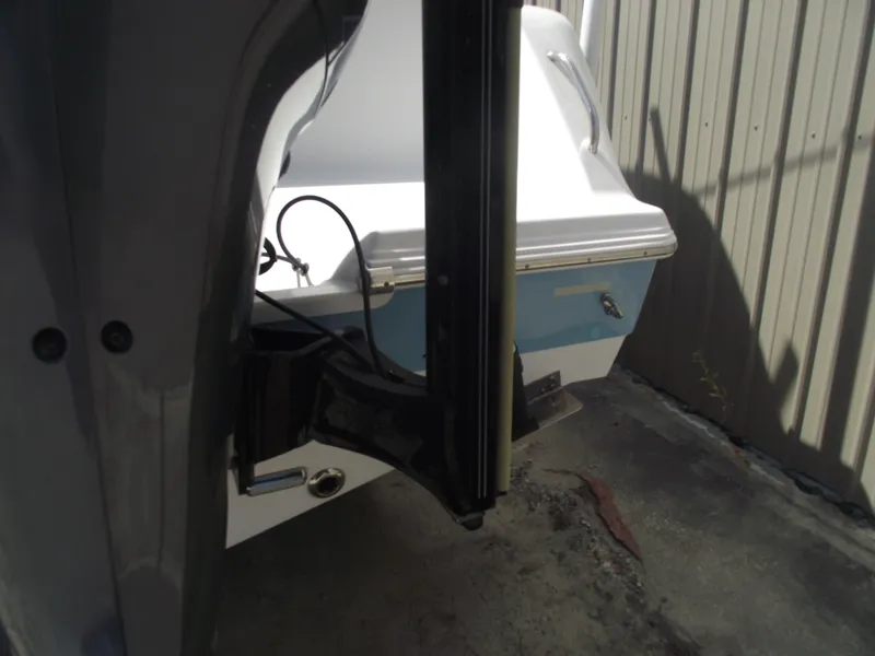 Slide: The Image of 2016 Sportsman Open 232 Center Console boat, rear view near a metal wall. - 7