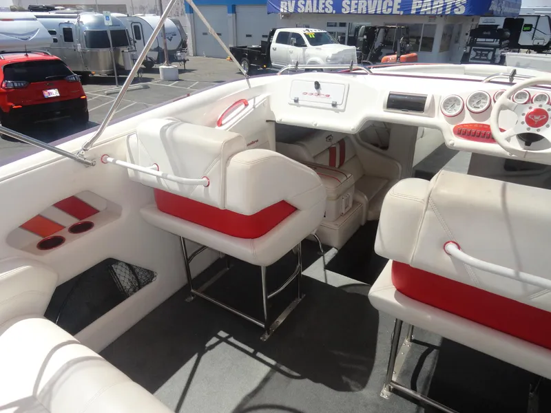 Slide: The Image of 2003 Cobra 270 Razor boat interior with white and red seating, dashboard, and steering wheel. - 13