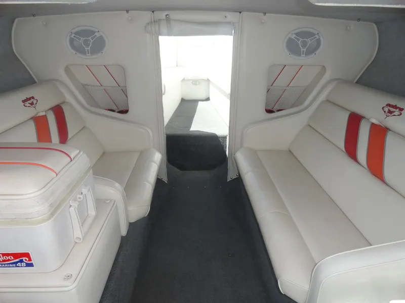 Slide: The Image of 2003 Cobra 270 Razor Mid-Cabin Open Bow interior with white seating and red accents. - 17