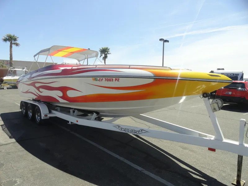 Slide: The Image of 2003 Cobra 270 Razor Mid-Cabin Open Bow boat with vibrant flame design on trailer. - 4