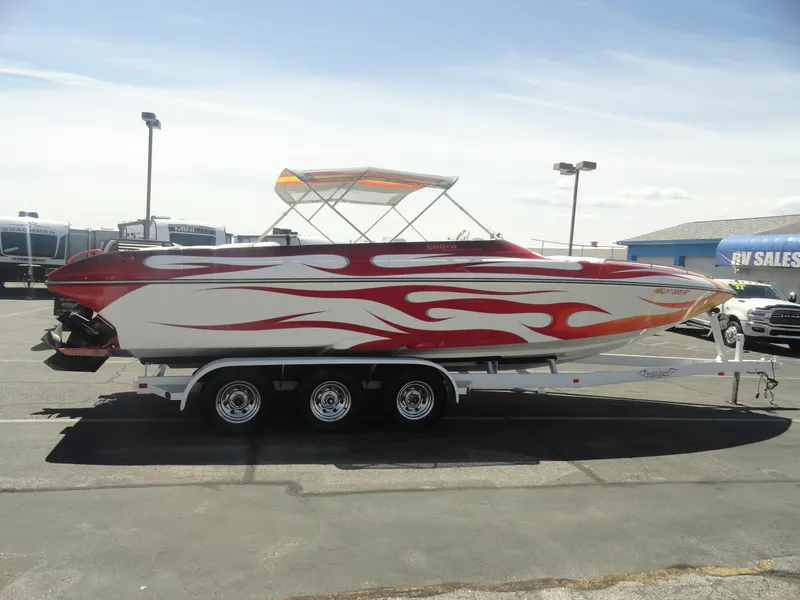 Slide: The Image of 2003 Cobra 270 Razor Mid-Cabin Open Bow boat with red flame design on trailer. - 5