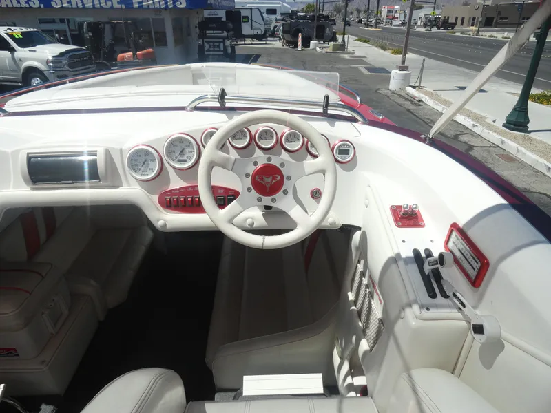 Slide: The Image of 2003 Cobra 270 Razor boat interior with white and red dashboard and steering wheel. - 8