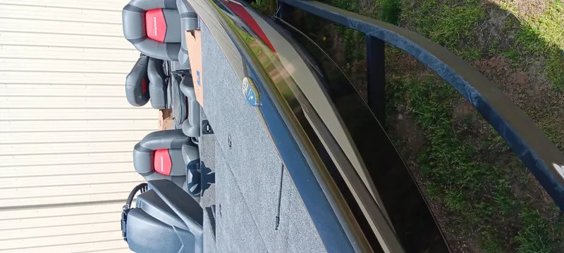 Slide: The Image of 2025 Tracker Savage 215 boat with seating, parked on grass beside a building. - 23