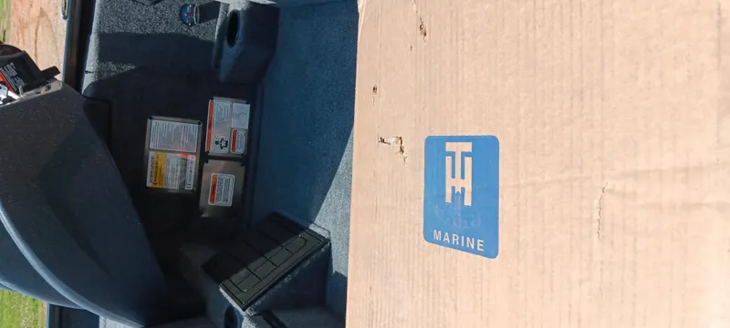 Slide: The Image of Cardboard box labeled "TH Marine" inside a 2025 Tracker Savage 215 boat. - 25