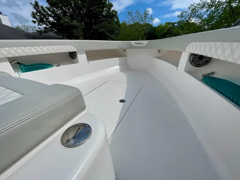 Slide: The Image of 2022 Front Runner 26 Center Console boat interior with white seating and speakers. - 13