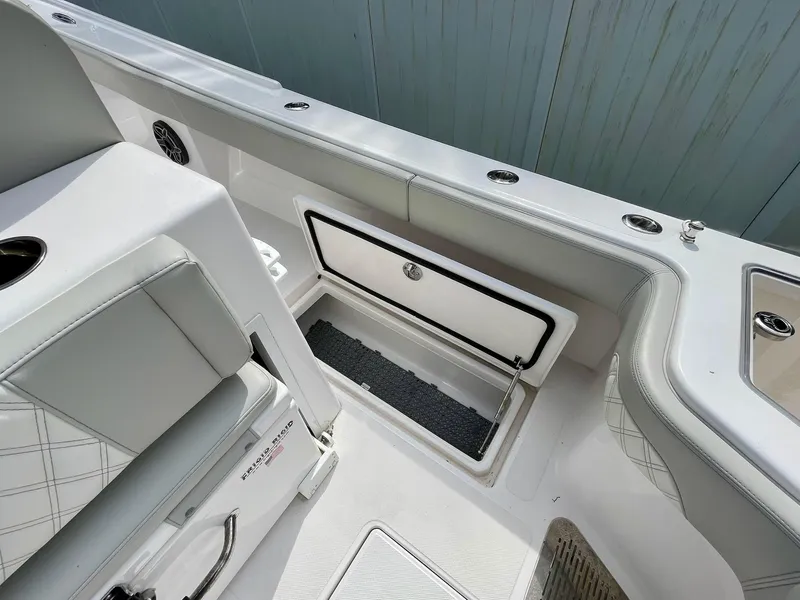 Slide: The Image of 2022 Front Runner 26 Center Console boat interior with storage compartment and seating. - 20