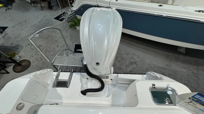 Slide: The Image of 2025 Edgewater 248 CX boat engine and deck view at a showroom. - 3
