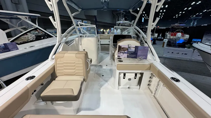 Slide: The Image of 2025 Edgewater 248 CX boat interior with beige seating and modern design at a boat show. - 6