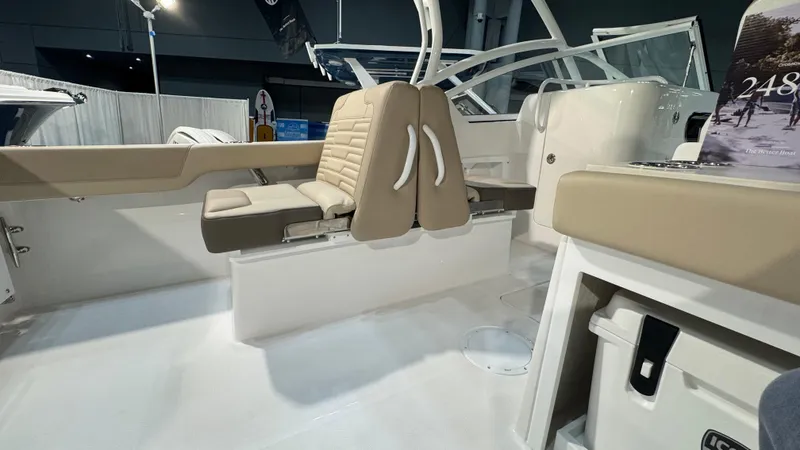 Slide: The Image of 2025 Edgewater 248 CX boat interior with beige seating and modern design. - 9