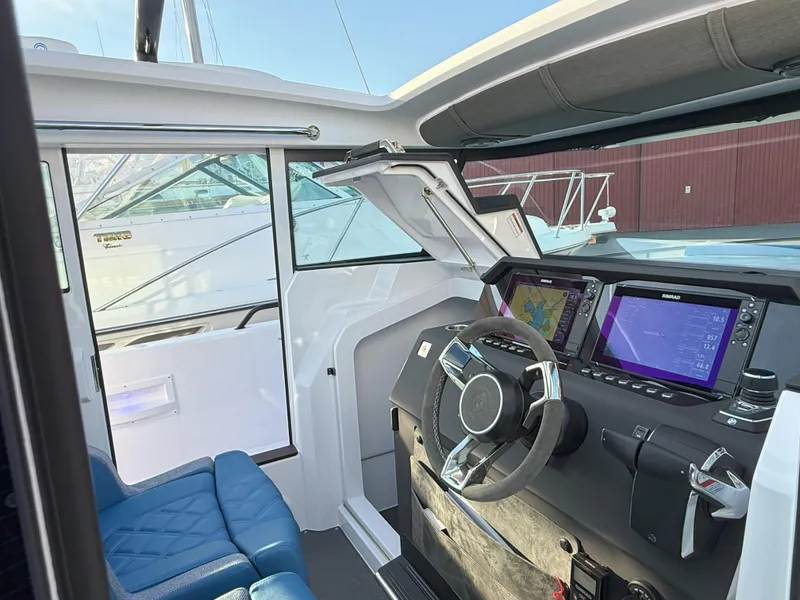 Slide: The Image of 2024 Axopar Cross Cabin interior with modern dashboard and blue seating. - 33