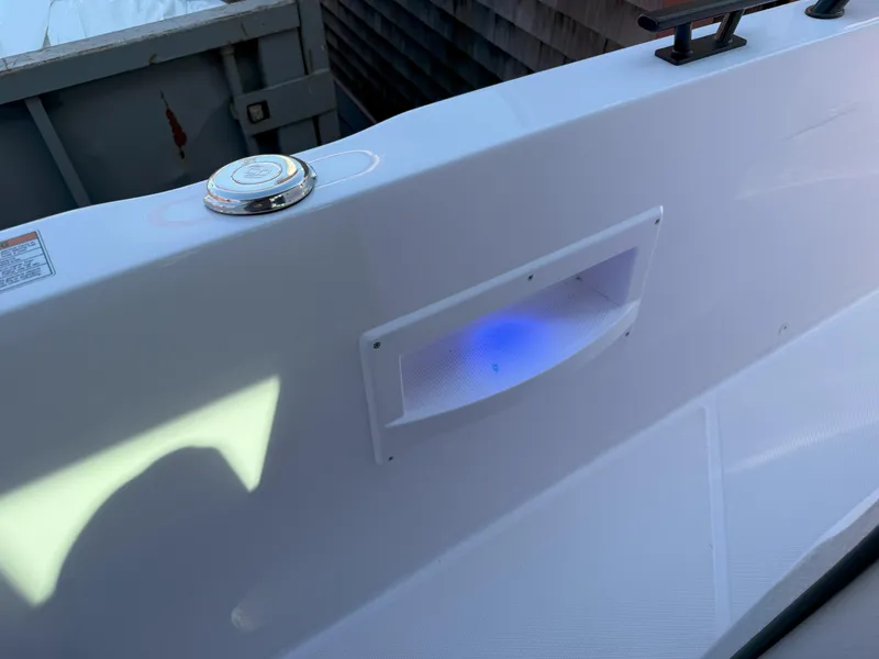 Slide: The Image of 2024 Axopar Cross Cabin boat deck with blue LED light and sleek design. - 43