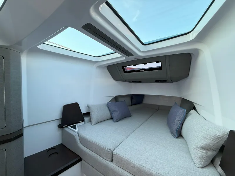 Slide: The Image of 2024 Axopar Cross Cabin interior with skylights, modern design, and comfortable seating. - 49