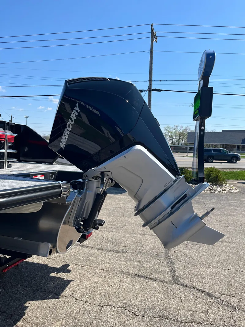 Slide: The Image of 2025 Bennington M Line boat with Mercury outboard motor in a parking lot. - 11