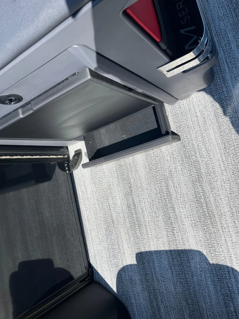 Slide: The Image of 2025 Bennington M Line boat interior with open storage compartment and sleek design. - 17