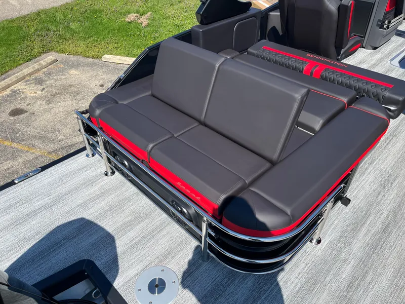 Slide: The Image of 2025 Bennington M Line boat with sleek black and red seating on a sunny day. - 25