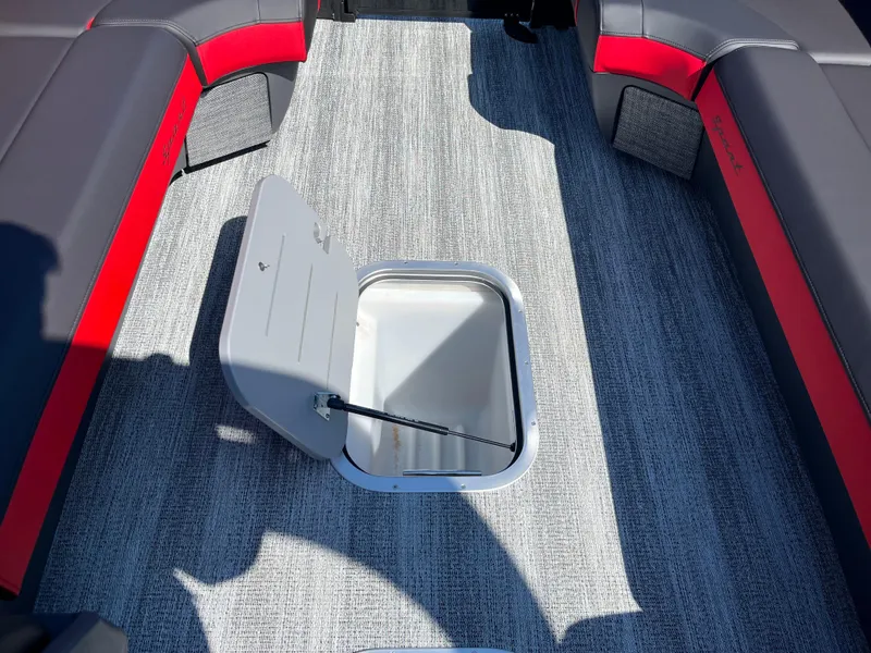 Slide: The Image of 2025 Bennington M Line boat interior with open storage compartment, gray and red seating. - 4