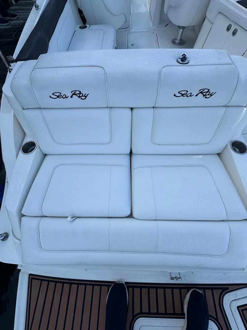 Slide: The Image of 2014 Sea Ray 260 Sundeck boat with white cushioned seating and cup holders. - 16
