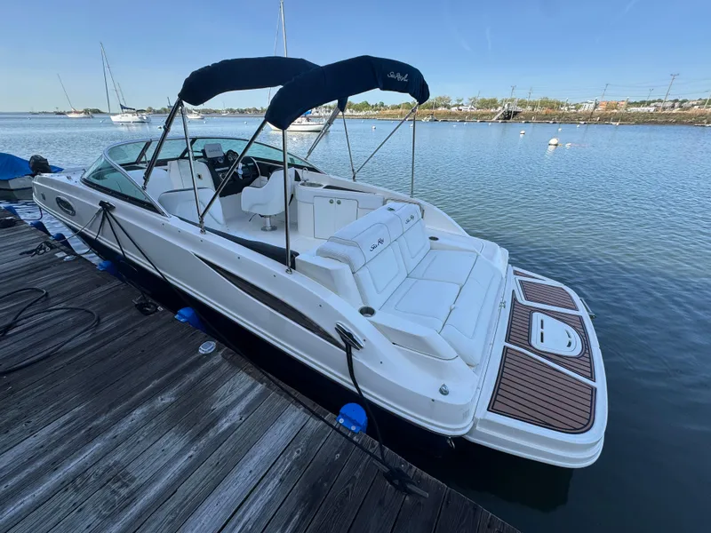 Slide: The Image of 2014 Sea Ray 260 Sundeck boat docked by the water, featuring a sleek design. - 2