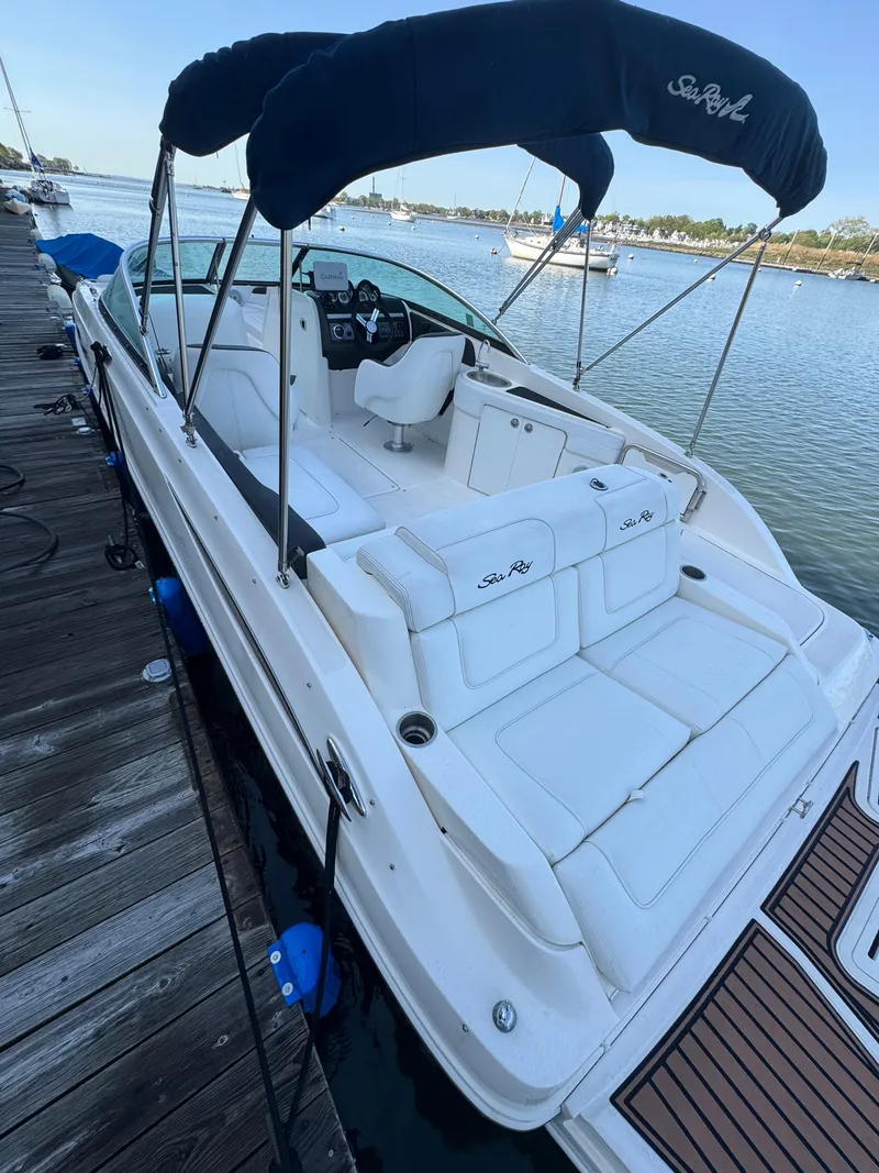 Slide: The Image of 2014 Sea Ray 260 Sundeck boat docked, featuring spacious seating and a canopy. - 3