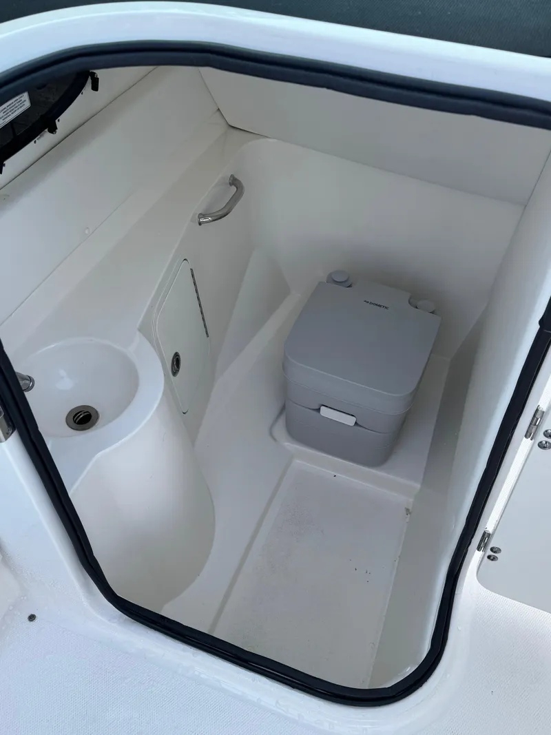 Slide: The Image of 2014 Sea Ray 260 Sundeck interior with compact marine toilet and sink. - 9