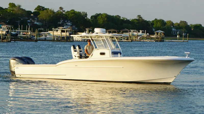 The Image of 2013 Buddy Davis 34 Center Console boat on calm water, with scenic shoreline background. - 1