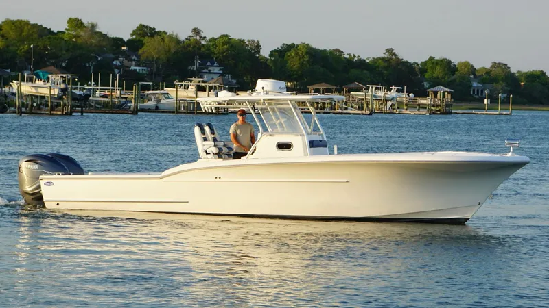 Slide: The Image of 2013 Buddy Davis 34 Center Console boat on calm water near a marina. - 10