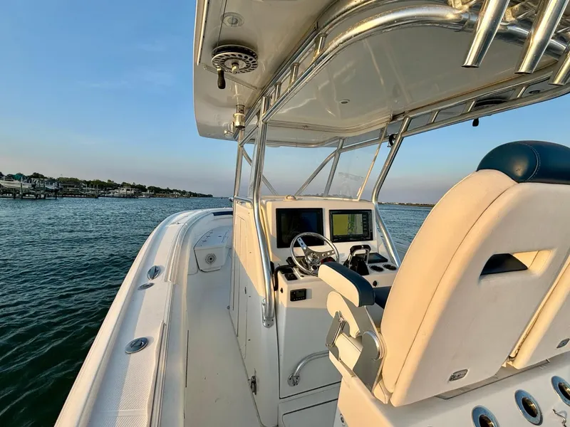 Slide: The Image of 2013 Buddy Davis 34 Center Console boat on calm water, featuring helm and seating area. - 16