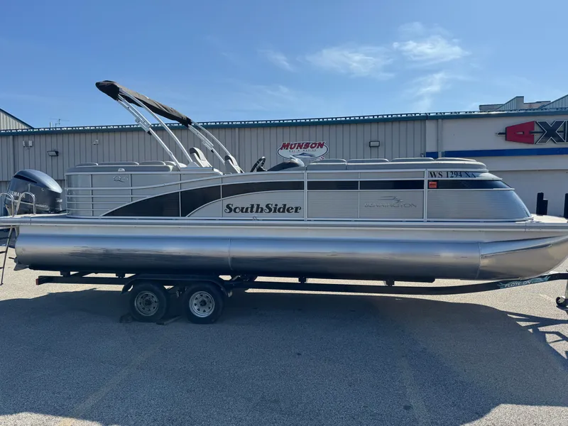 Slide: The Image of 2020 Bennington Q 25 QSR pontoon boat on trailer, parked outdoors under clear sky. - 22