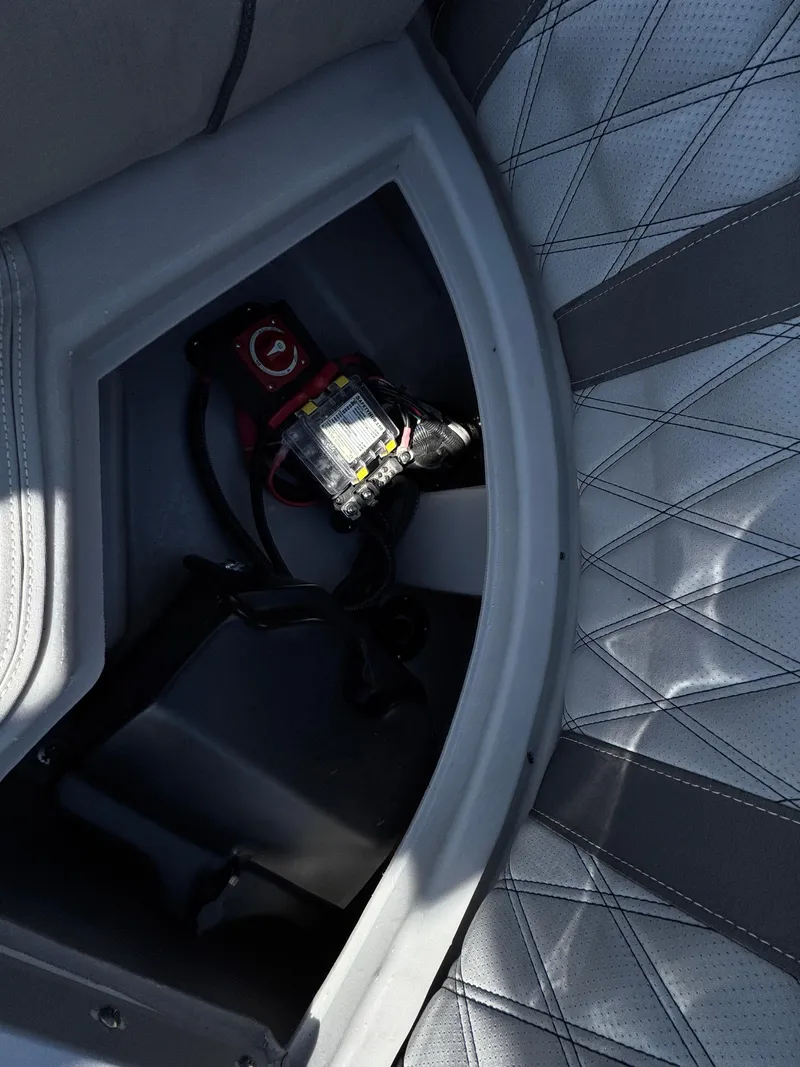 Slide: The Image of 2020 Bennington Q 25 QSR boat interior with storage compartment and electrical components. - 25