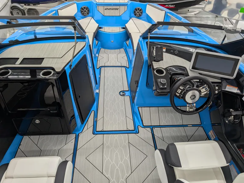 Slide: The Image of 2023 Yamaha Boats 222XD interior with modern dashboard and seating, featuring blue and gray accents. - 3