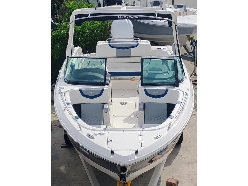 Slide: The Image of 2024 Chaparral 270 OSX boat with open deck and seating, docked outdoors. - 2