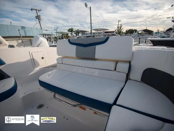 Slide: The Image of 2024 Chaparral 270 OSX boat interior with white and blue seating, outdoor setting. - 21