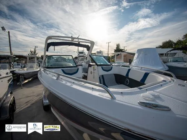 Slide: The Image of 2024 Chaparral 270 OSX boat under a bright sky at a marina. - 6