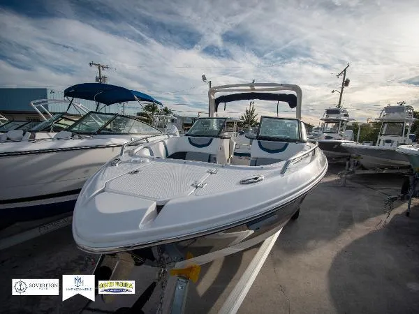 Slide: The Image of 2024 Chaparral 270 OSX boat displayed in a marina under a cloudy sky. - 7