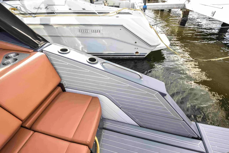 Slide: The Image of 2021 Cruisers Yachts 42 GLS OB, featuring sleek seating and modern design at a marina. - 18