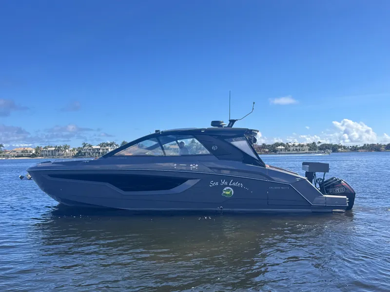 Slide: The Image of 2021 Cruisers Yachts 42 GLS OB on calm water under clear blue sky. - 2