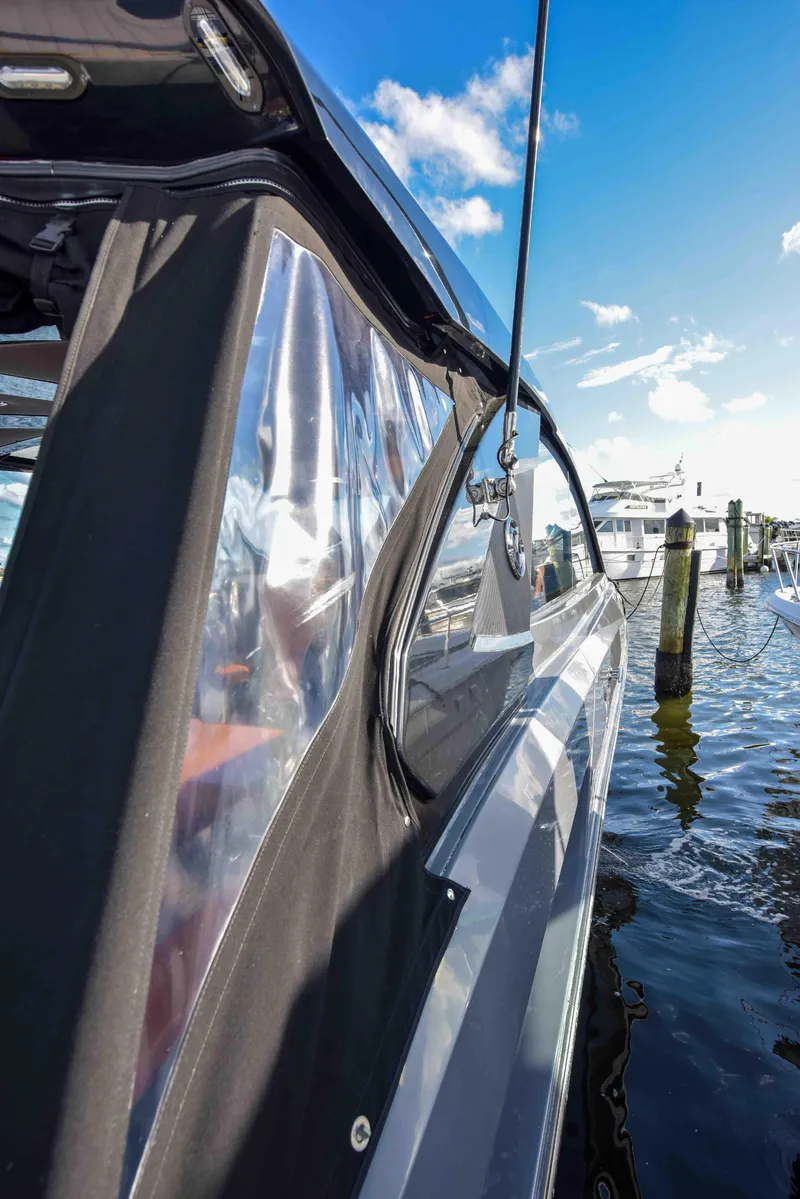Slide: The Image of 2021 Cruisers Yachts 42 GLS OB docked, showcasing sleek design and clear canopy under blue sky. - 22