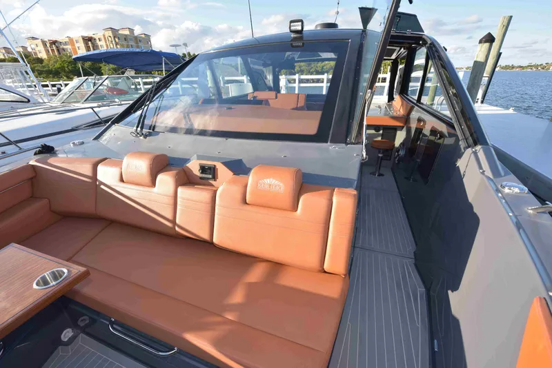 Slide: The Image of 2021 Cruisers Yachts 42 GLS OB with luxurious seating and sleek design at a marina. - 47