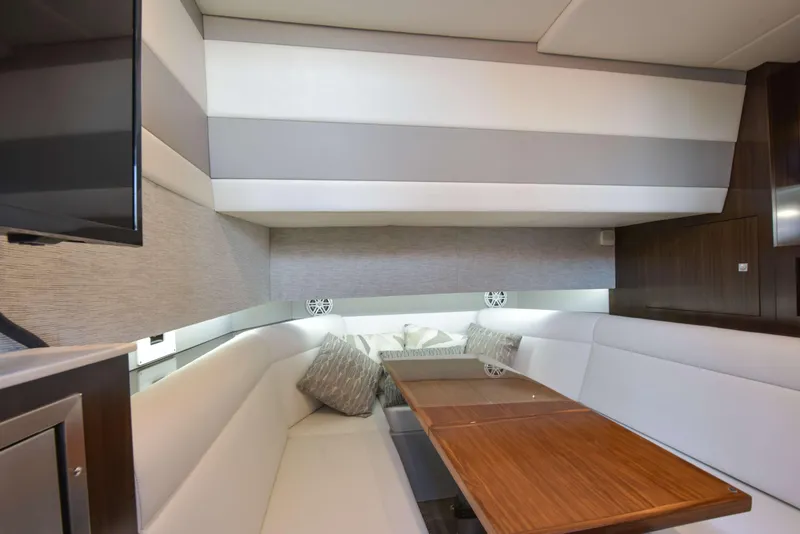 Slide: The Image of 2021 Cruisers Yachts 42 GLS OB interior with elegant seating and wooden table. - 49