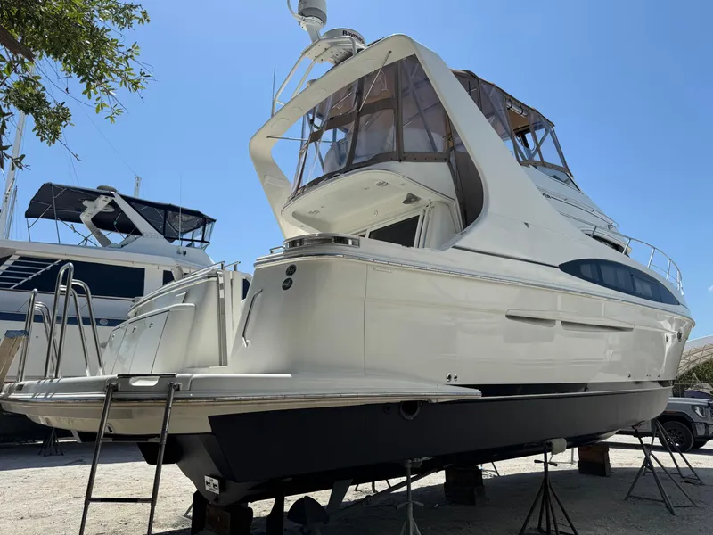 Slide: The Image of 2004 Carver 420 Mariner yacht on dry dock, showcasing sleek design and spacious deck. - 1
