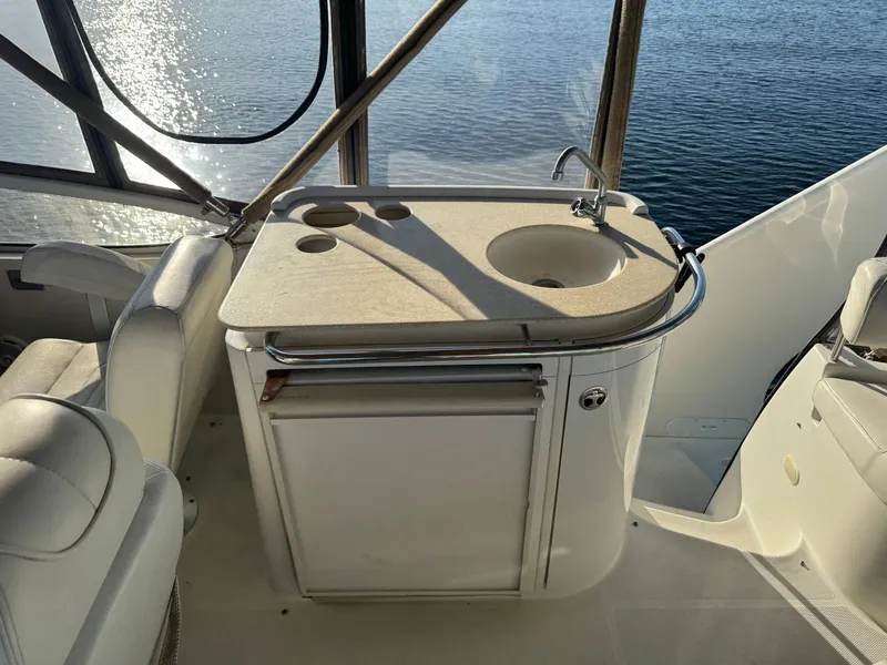 Slide: The Image of 2004 Carver 420 Mariner yacht kitchenette with sink and storage, overlooking water. - 17