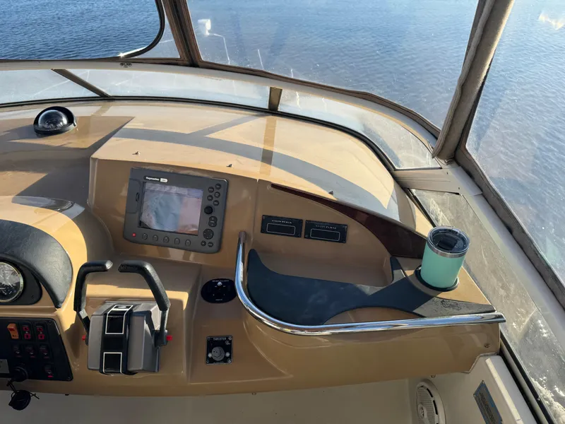 Slide: The Image of Helm of 2004 Carver 420 Mariner with navigation controls and cup holder. - 18