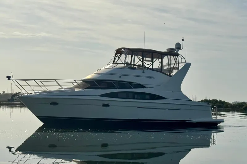 Slide: The Image of 2004 Carver 420 Mariner yacht on calm water under a cloudy sky. - 22