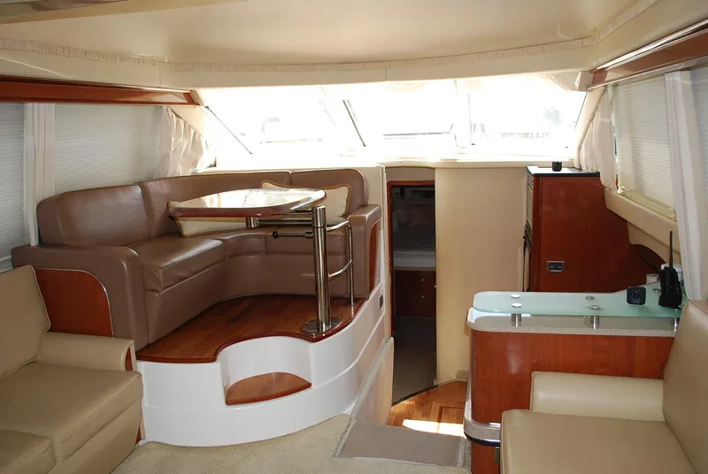 Slide: The Image of Interior of 2004 Sea Ray Sedan Bridge yacht with leather seating and wooden accents. - 13