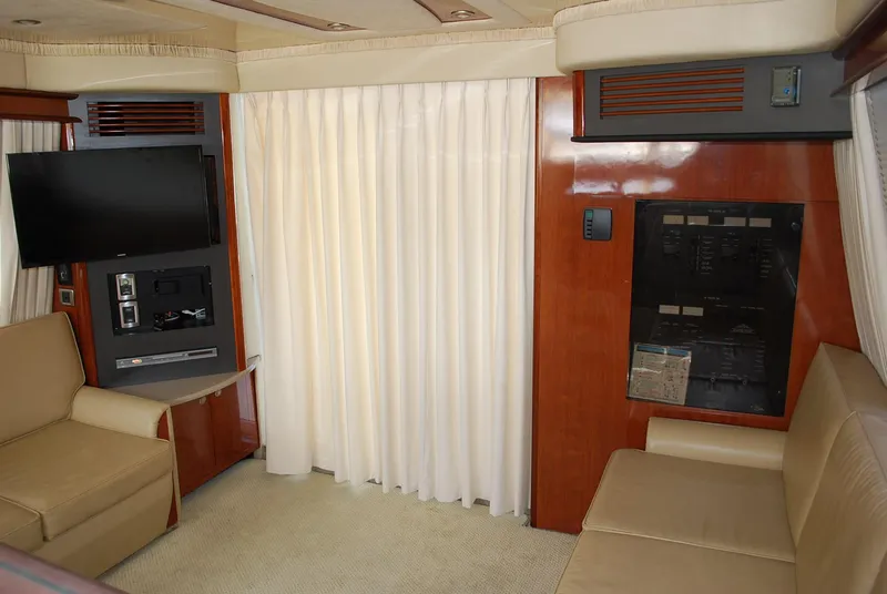 Slide: The Image of Interior of 2004 Sea Ray Sedan Bridge yacht with beige seating and entertainment system. - 14