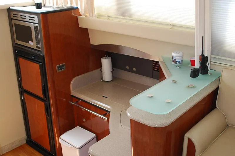 Slide: The Image of 2004 Sea Ray Sedan Bridge yacht interior with kitchenette, featuring microwave and modern design. - 17