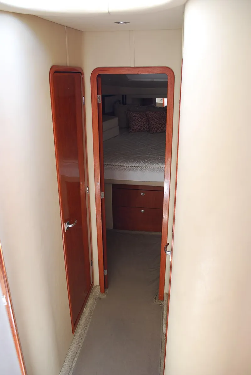 Slide: The Image of 2004 Sea Ray Sedan Bridge interior hallway leading to a cozy bedroom. - 21