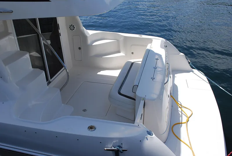 Slide: The Image of 2004 Sea Ray Sedan Bridge yacht deck with seating, steps, and water view. - 5