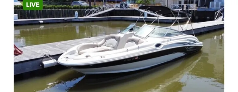 Slide: The Image of 2004 Sea Ray 270 Sundeck boat docked in a marina, featuring sleek design and spacious seating. - 0