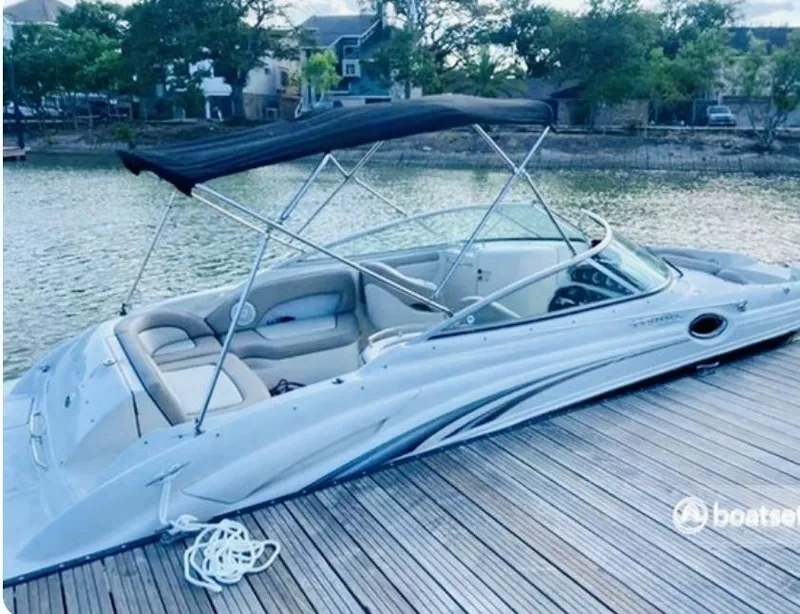 Slide: The Image of 2004 Sea Ray 270 Sundeck boat docked by a serene waterfront. - 1